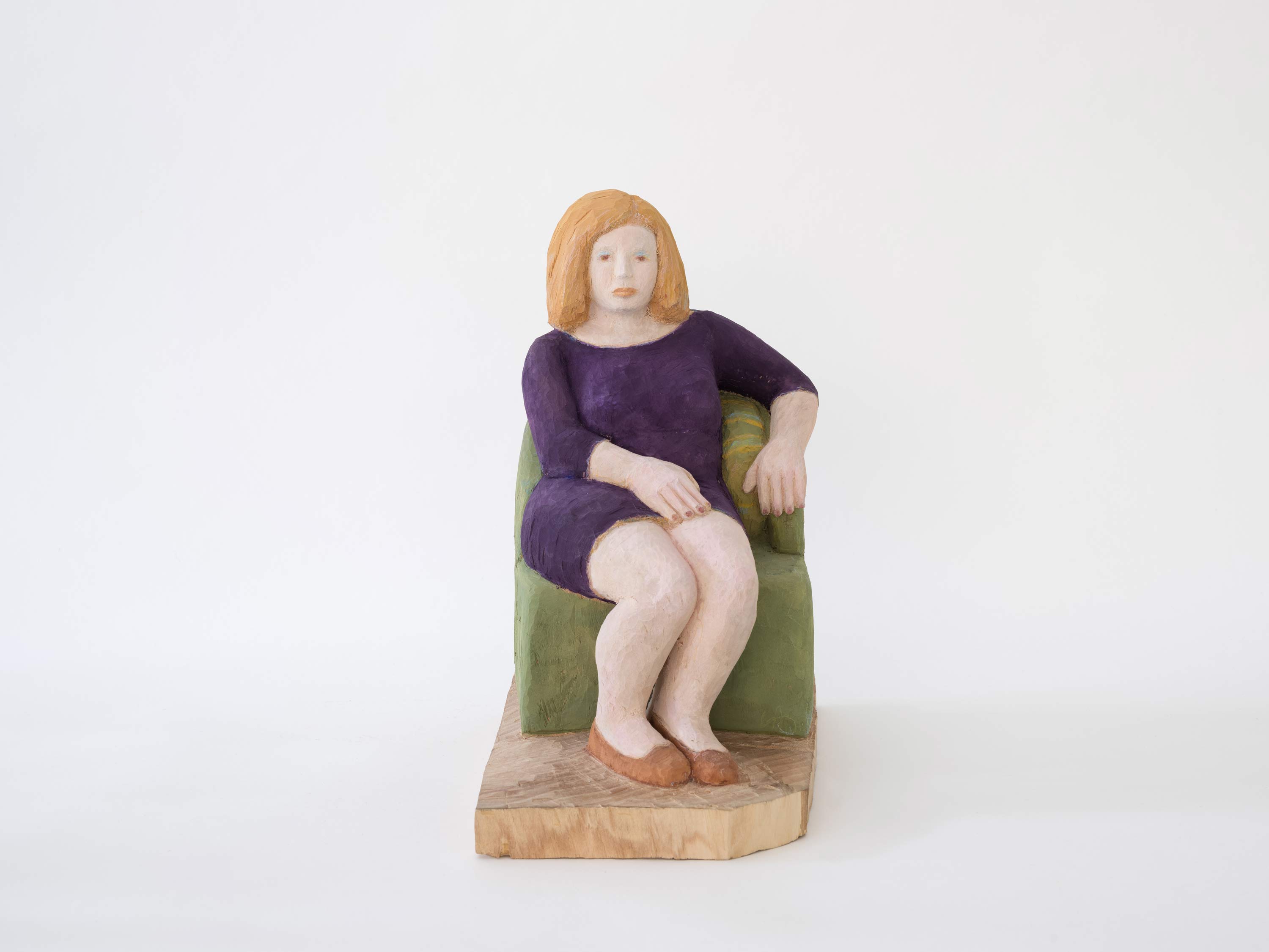 Holzskulptur von Ursula Bucher mit dem Titel: Sitzende auf grünem Fauteuil